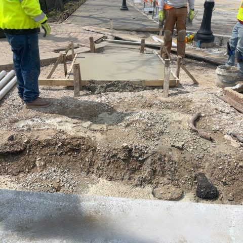 Construction workers repairing Waukegan road in IL for community improvement.