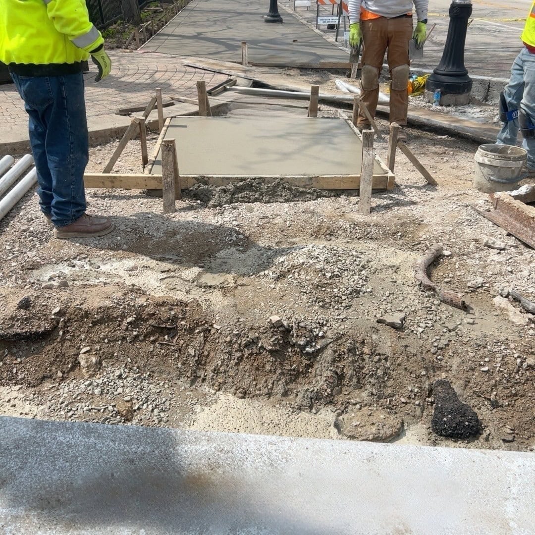 Construction workers repairing Waukegan road in IL for community improvement.