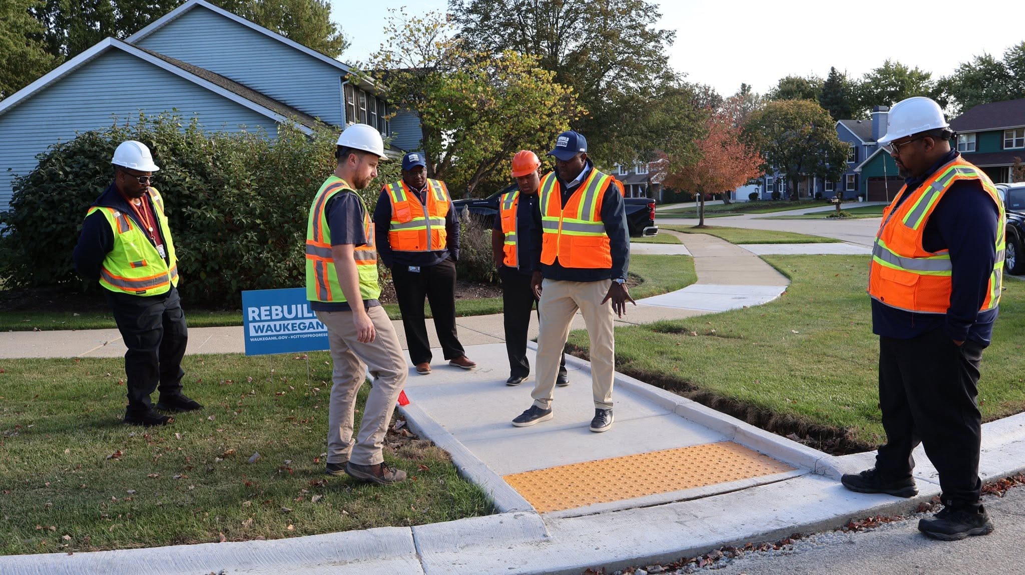 Group of workers inspecting a new pedestrian crosswalk in Waukegan, IL.